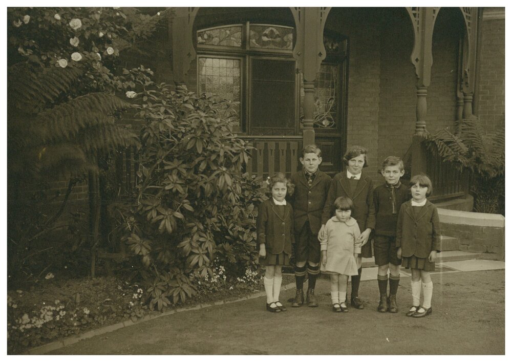 John Buxton outside family home in School uniform with five of his siblings, 1920s