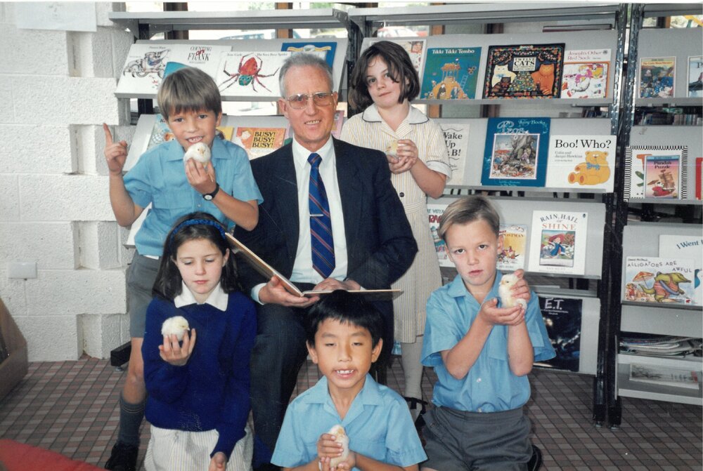 Don Brown in library with students holding chicks, circa 1991