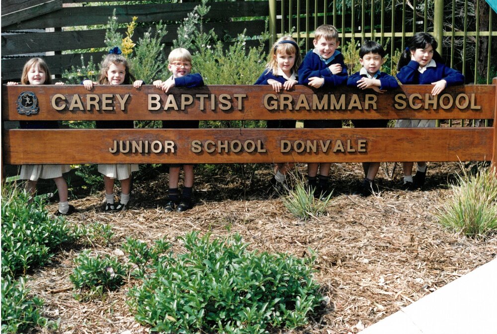 Donvale students standing behind entrance sign, 1990s