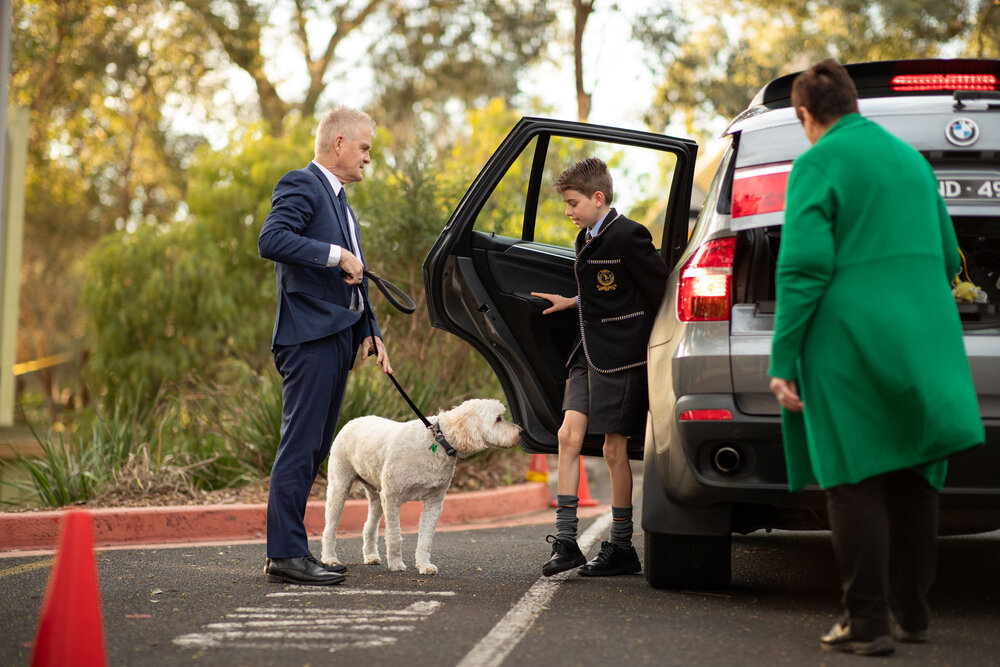Steve Wilson and Archie greet an arriving student, 2021