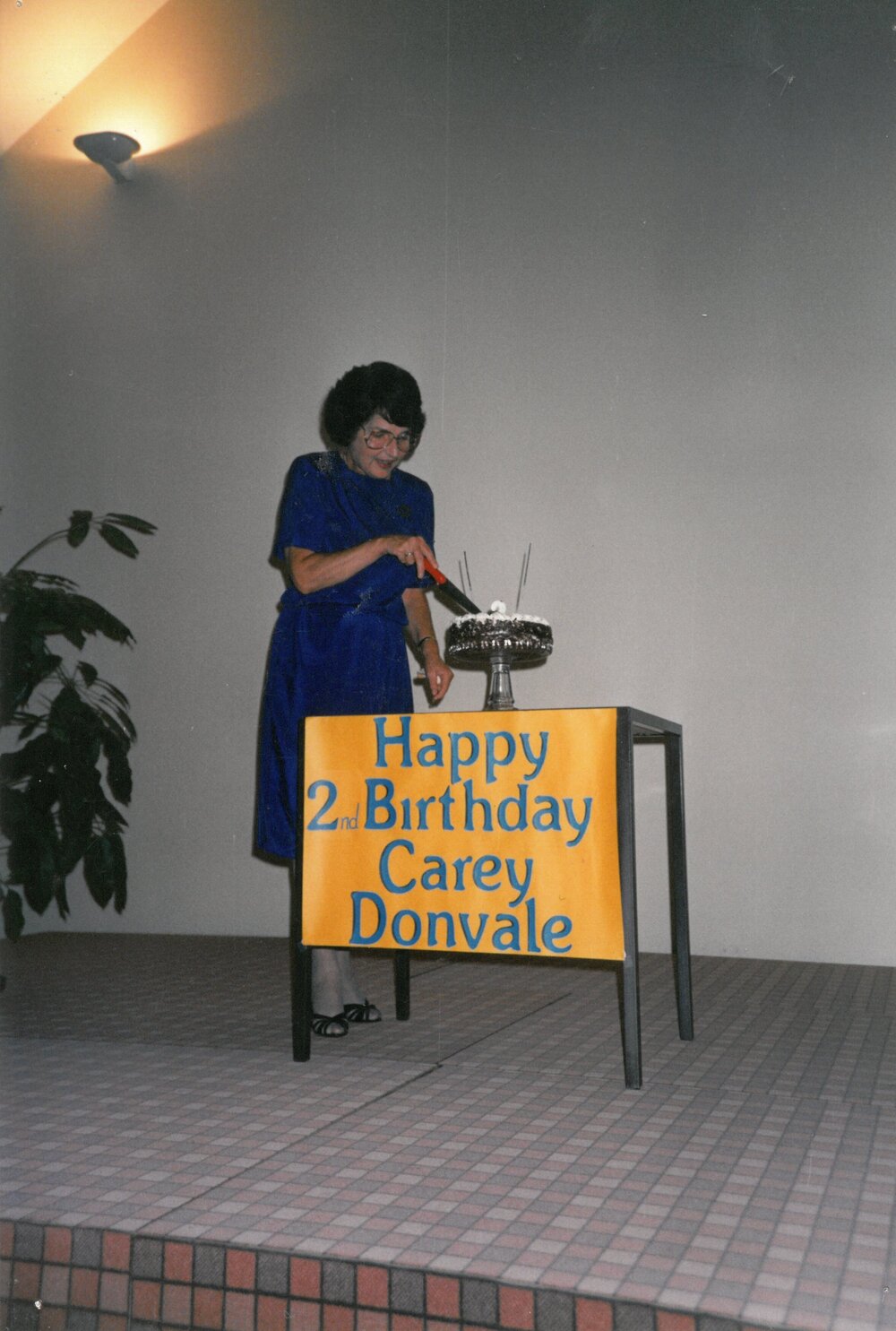 Shirley Allen cutting cake, 1991