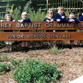 Donvale students standing behind entrance sign, 1990s