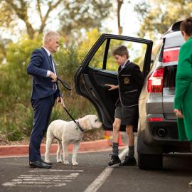 Steve Wilson and Archie greet an arriving student, 2021