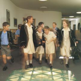 Students walking on glass skylight in Hickman Building, 1994