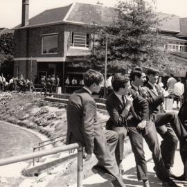 Students conversing on the bank of the Sandell Oval, 1967