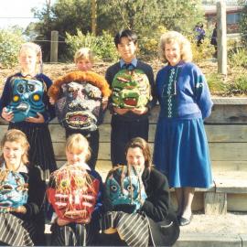 Wendy Weeks (Hirt) with students displaying papier-mâché masks, 1990s