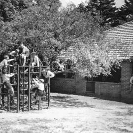 Junior School students on climbing frame in Junior School playground, 1960s