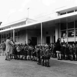 Junior School students queuing outside classrooms with teachers, 1970